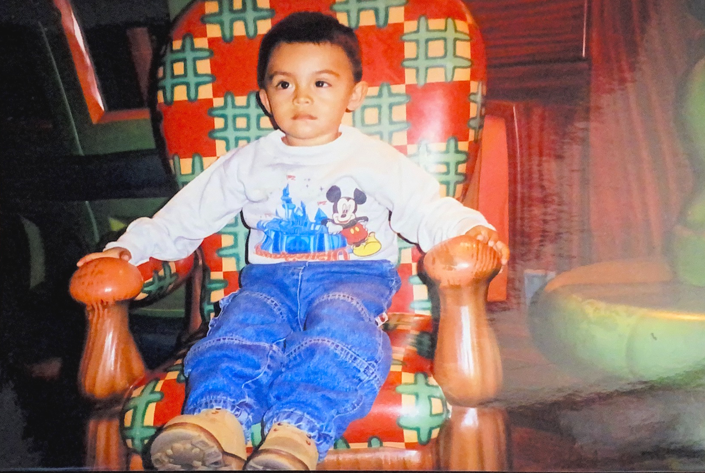 Boy sitting in a red chair.